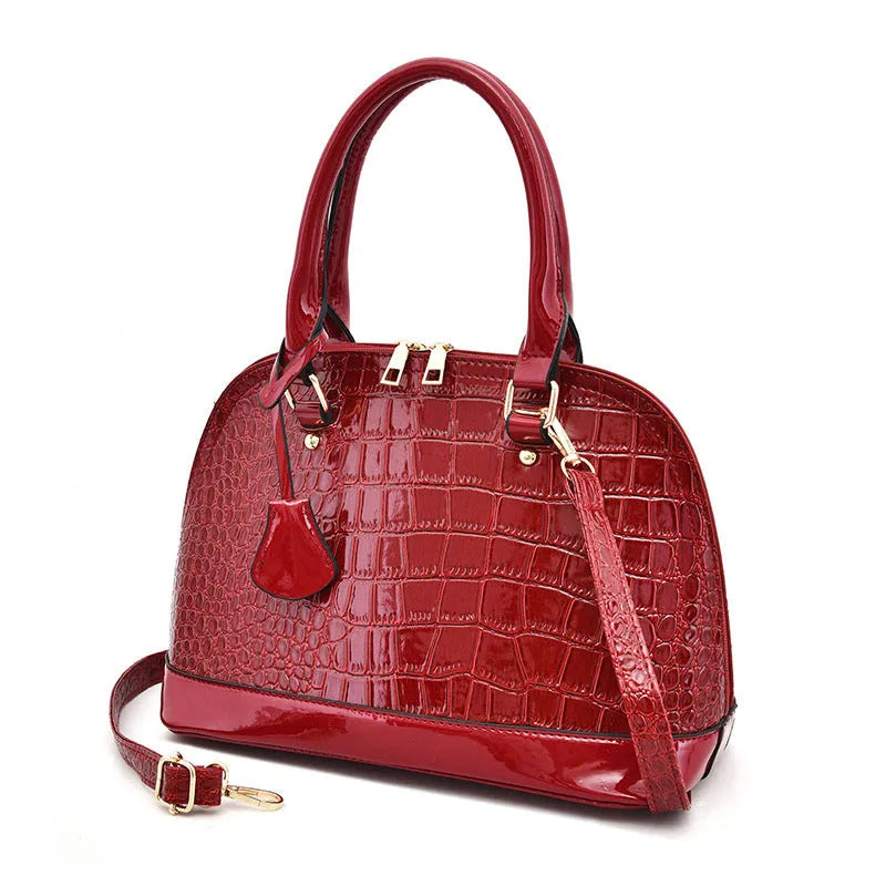 Shiny PU shoulder bag in shell shape showing black, brown, and red colour options