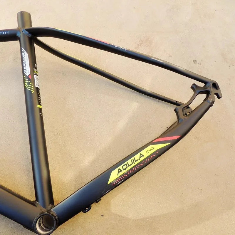 Black green aluminium 29-inch mountain bike frame showing disc brake mount and internal cable routing ports.
