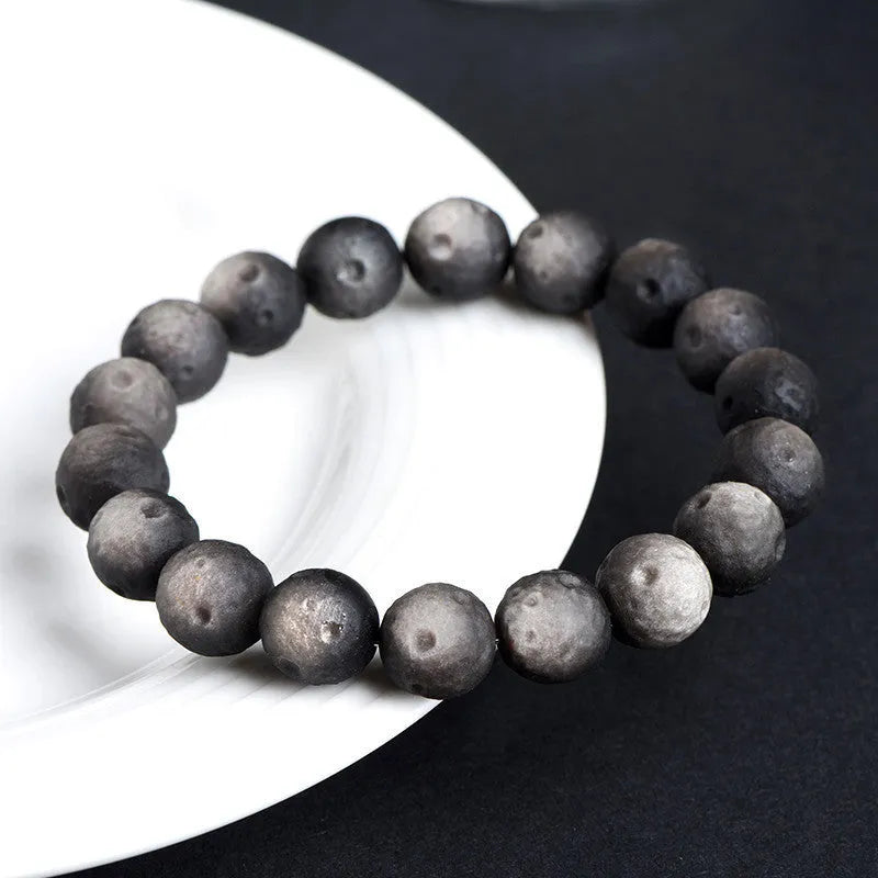Obsidian ball bracelet with natural crater texture in silver stone meteorite colour with grinding finish