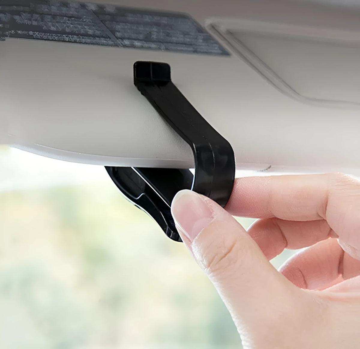 Black plastic car sun visor clip for holding glasses and cards.