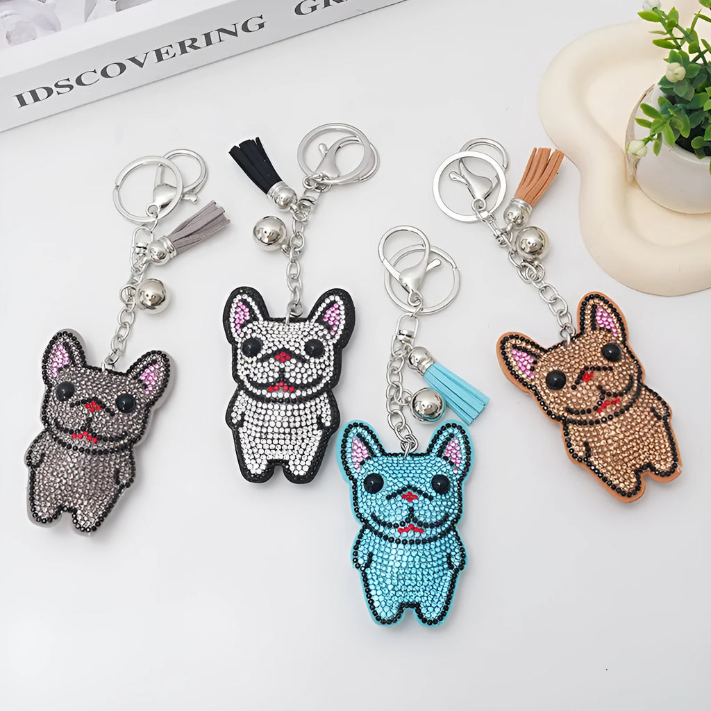 Close-up of a caramel-coloured cartoon dog rhinestone keychain pendant on a keyring.