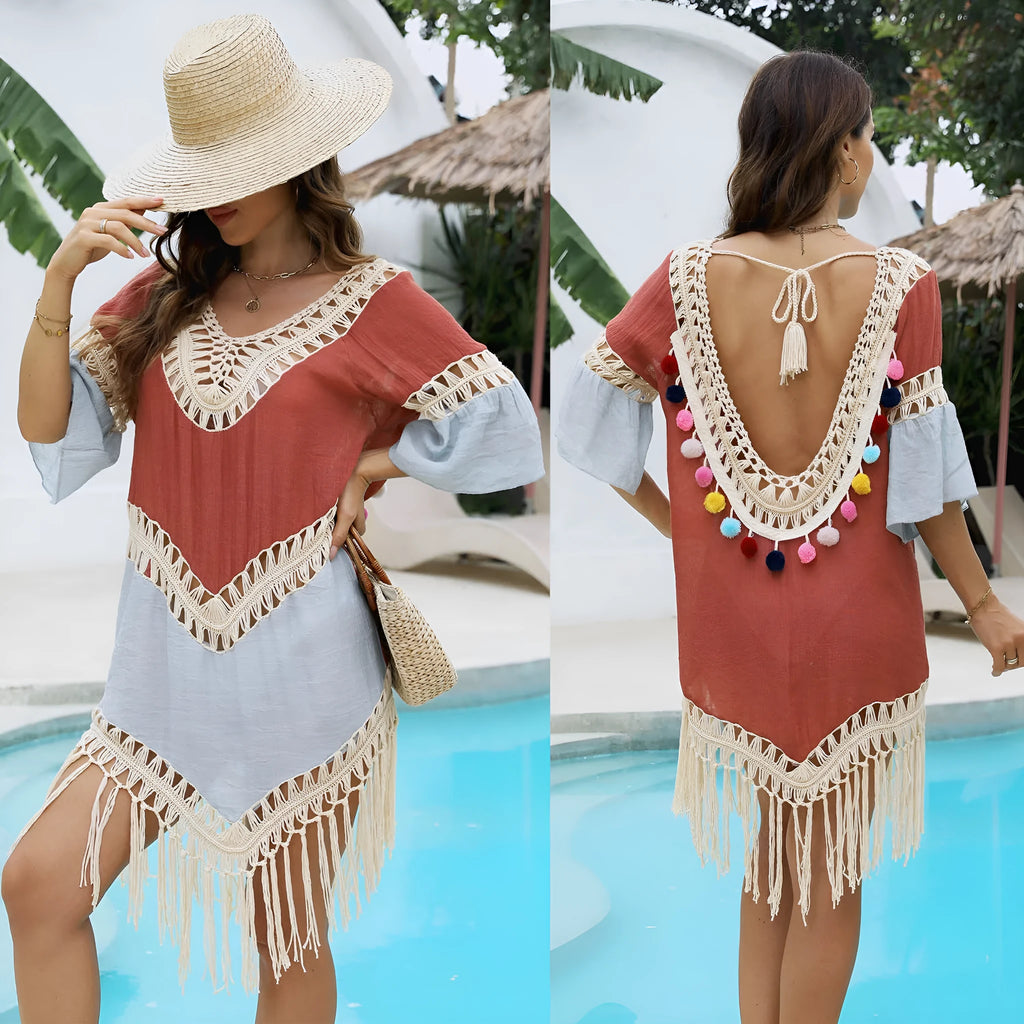 Orange floral print beach overskirt with hand crochet detail and tassels, laid flat.
