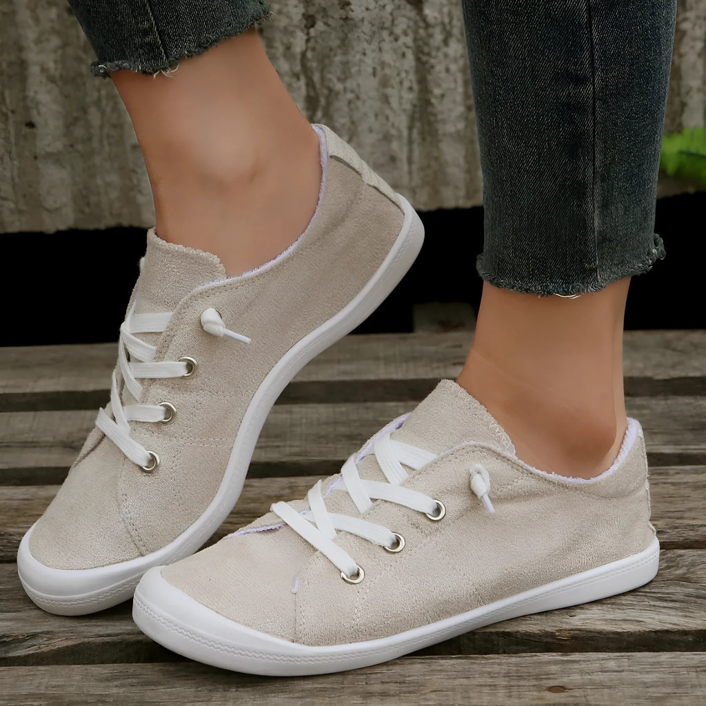 Women's creamy-white low-top fabric sneaker with rubber sole shown from side view