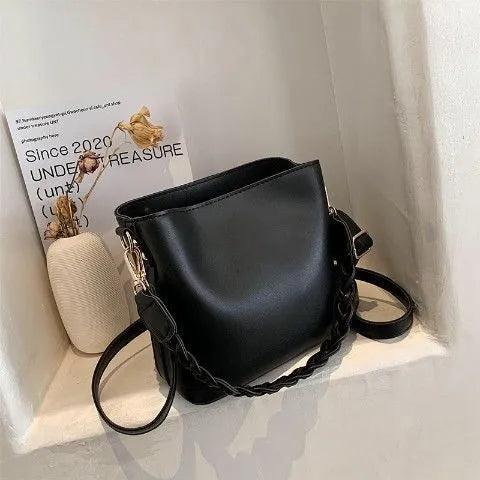 Retro woven crossbody bucket bag in khaki colour showing one-shoulder strap and textured PU material.