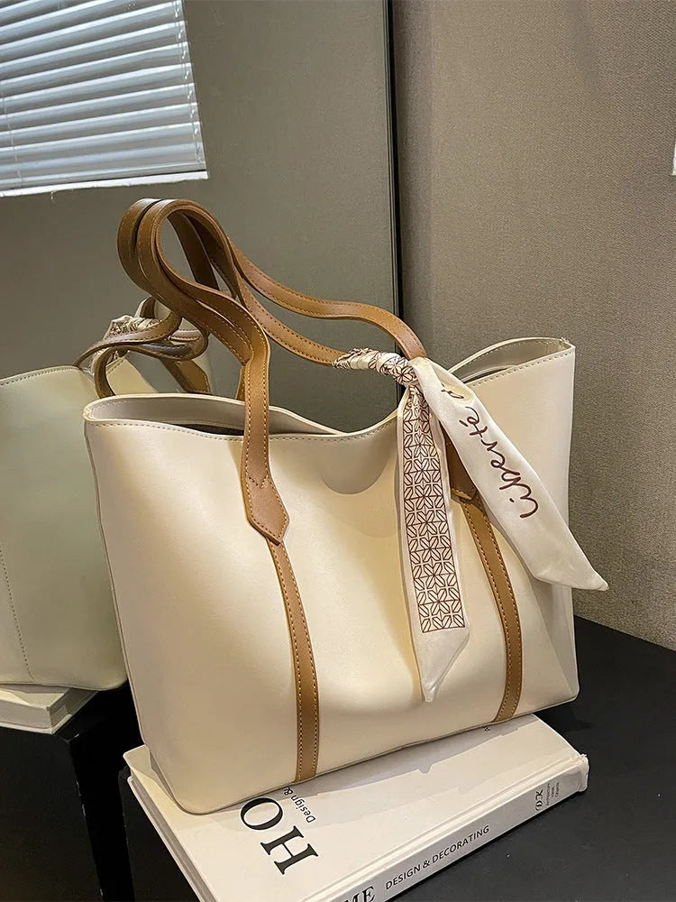 Women's soft bucket shoulder bag in various colours showing crossbody strap and zippered compartment