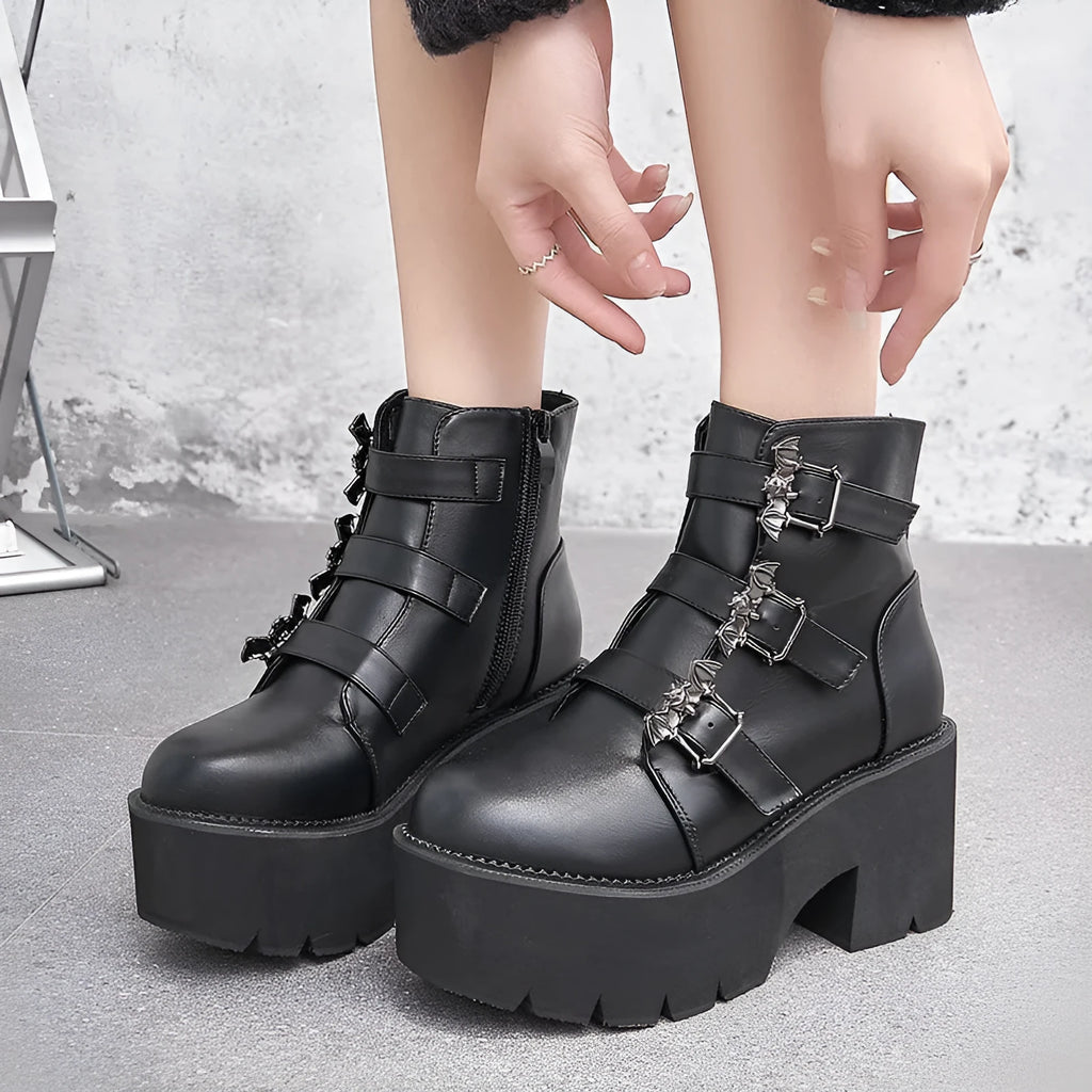 Black women's gothic punk Martin boots with a silver bat buckle and side zip.
