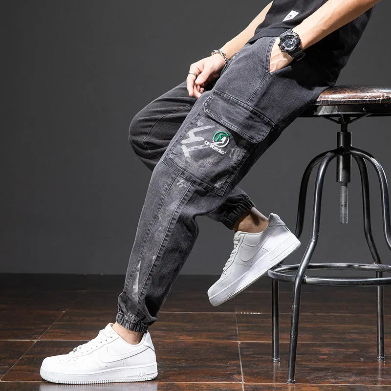 Man wearing straight leg cotton cargo jeans in blue, showing mid waist and skinny open leg style.