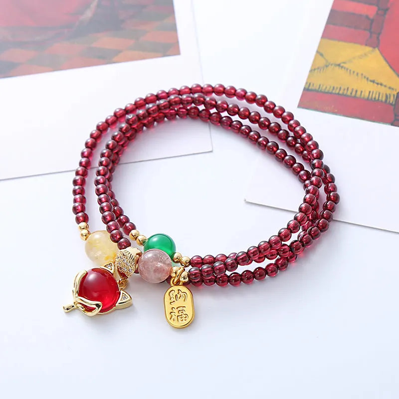 Purplish red garnet fox charm bracelet on an adjustable rope for women.