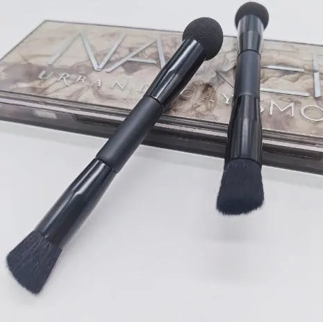 Elegant black double-headed makeup brush with miter sponge and angled concealer heads on a wooden handle.