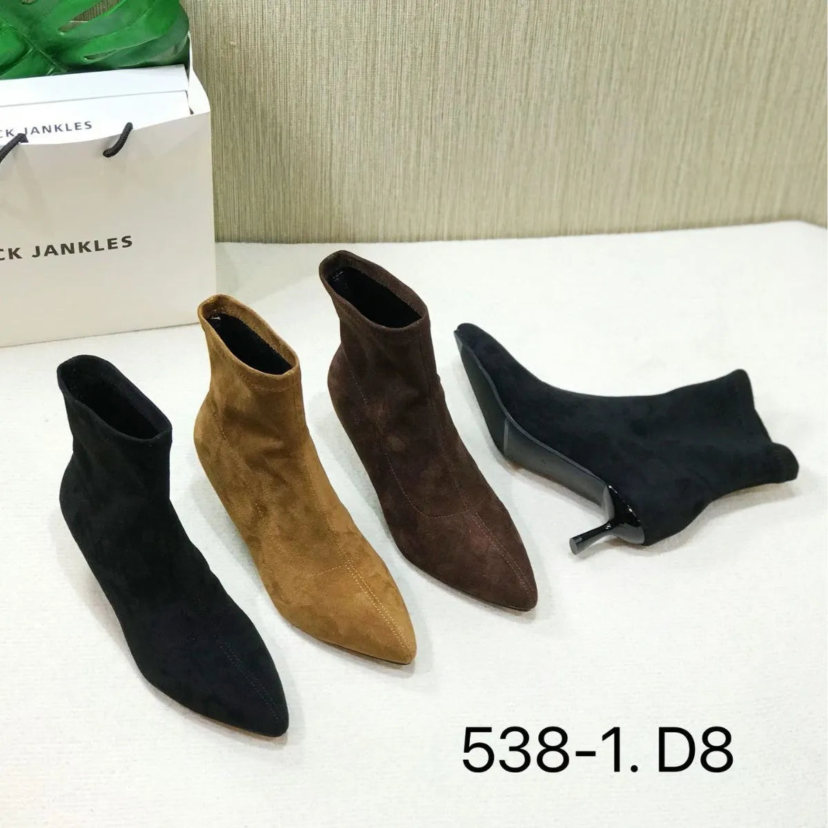 Women's black pointed toe ankle boots with a stiletto heel on a white background.