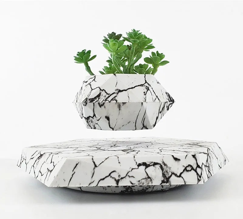 Small marble-colour plastic plant pot floating above a magnetic base unit.