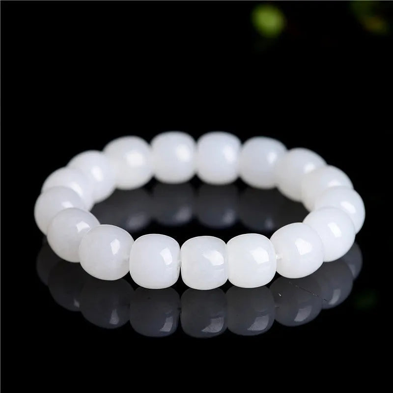 White Hetian jade barrel bead bracelet on a wrist, showing the smooth beads and casual unisex design.