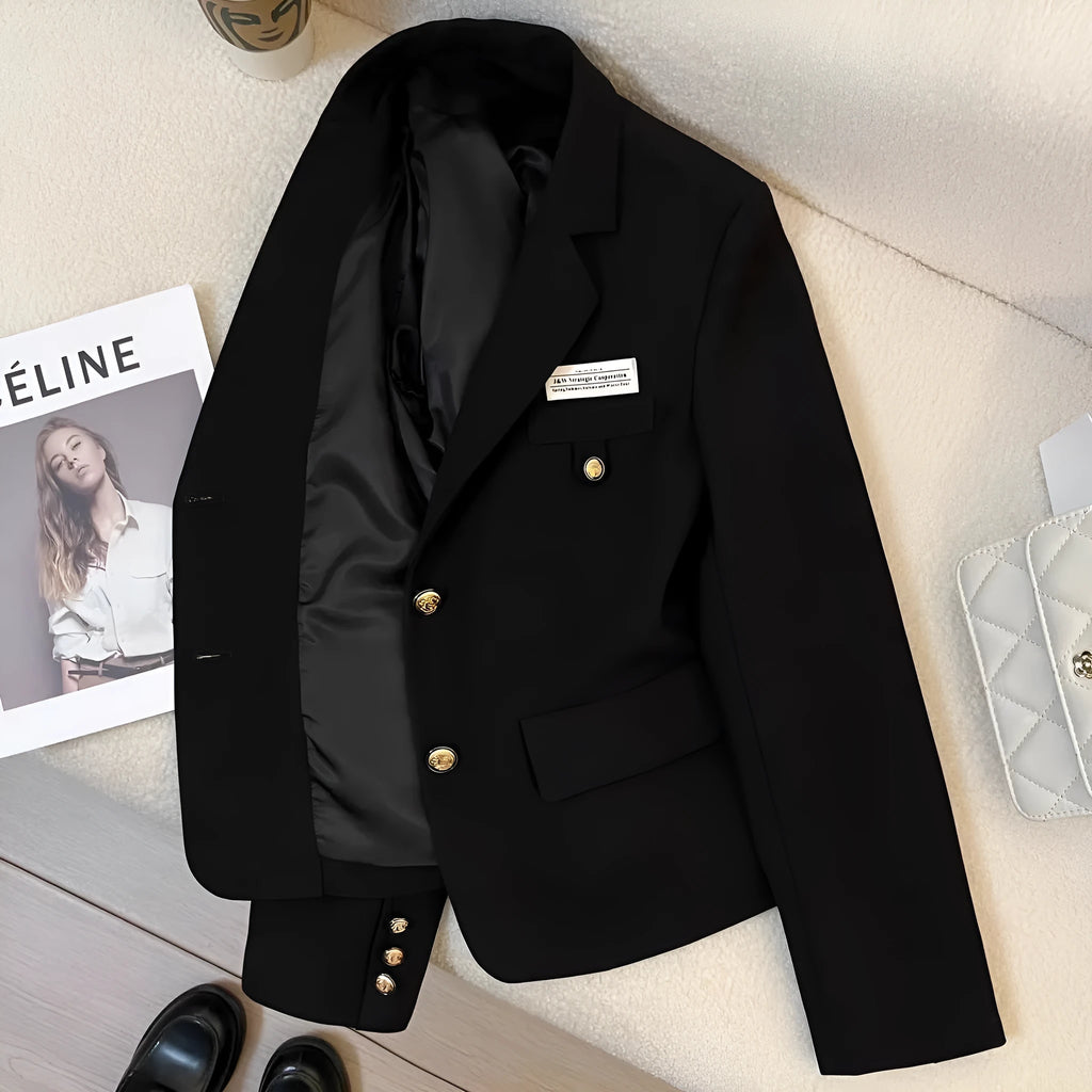 Women's black loose-fit suit coat with long sleeves and pockets on a hanger.