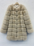Women's long artificial fur coat in a choice of five colours, shown in a commute style setting.