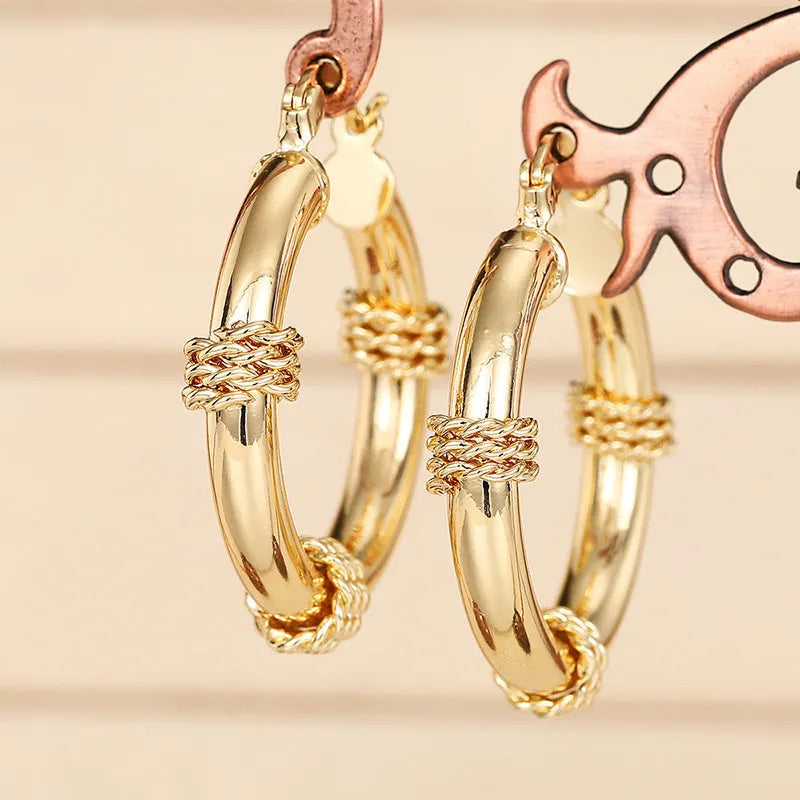 Geometric copper ear clips for women in a golden colour with clean line detailing on a white background.