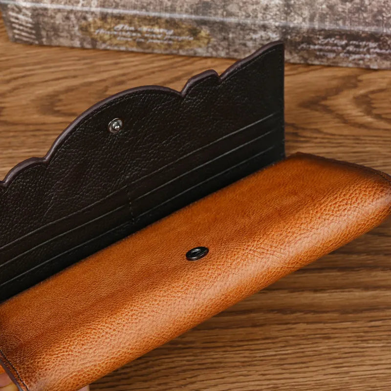 Women's brown embossed floral genuine leather tri-fold wallet showing interior compartments
