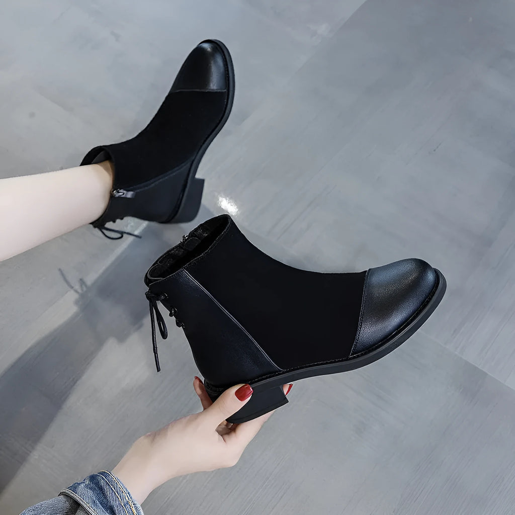 Black women's knee-high Martin boots with side zip and round toe on a rubber sole.