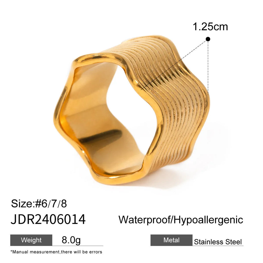 Close-up of a stainless steel geometric wave ring with a wide, sculpted surface.