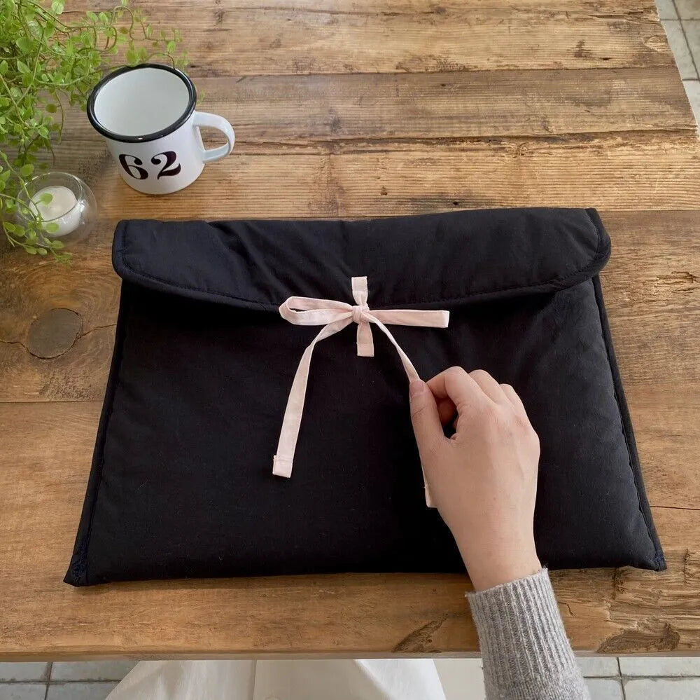 Women's black quilted computer bag with ballet style bow and striped pattern