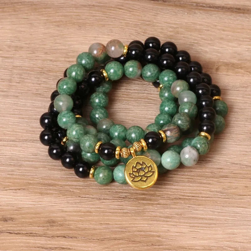 Green and black alloy bead elastic bracelet on wrist showing adjustable stretch design