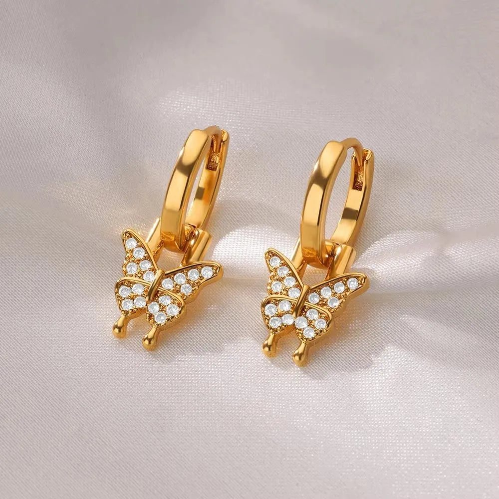A pair of women's geometric butterfly-shaped earrings made from copper with heart and star details.