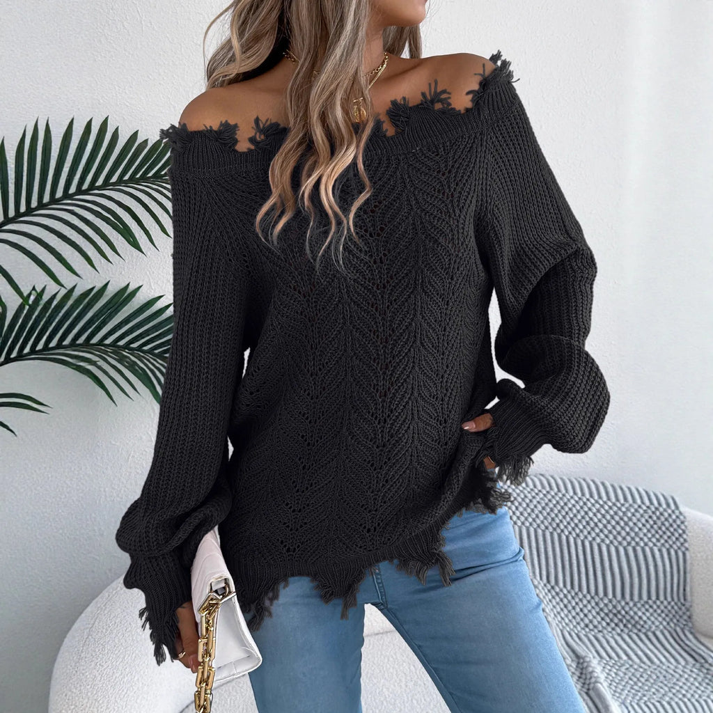 White hollow-out cut off-the-shoulder long sleeve pullover sweater on a hanger showing acrylic knit fabric detail.