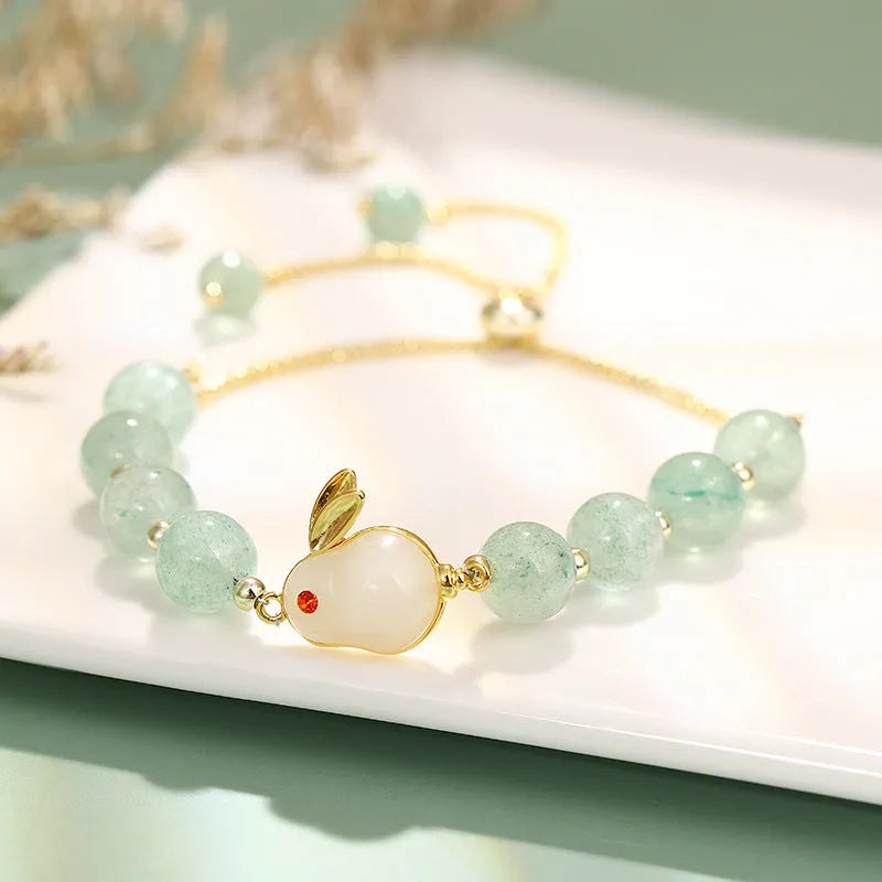 Rabbit charm bracelet with green aventurine and strawberry quartz stones on a gold or copper chain.