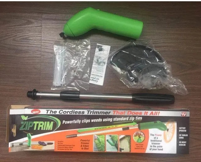 Cordless handheld lawn trimmer with extension pole and protective shield on a garden lawn.