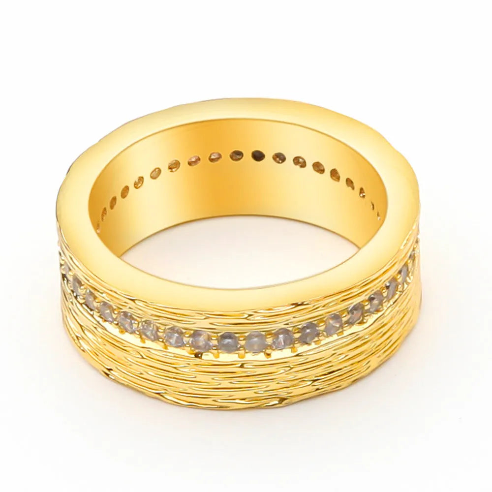 Gold-coloured geometric zircon ring for women on a plain background.