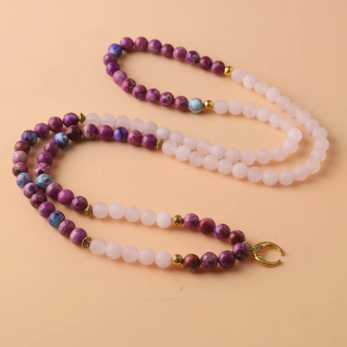 Women's personalised necklace with round Emperor Stone bead pendant showing pink crystal colouration