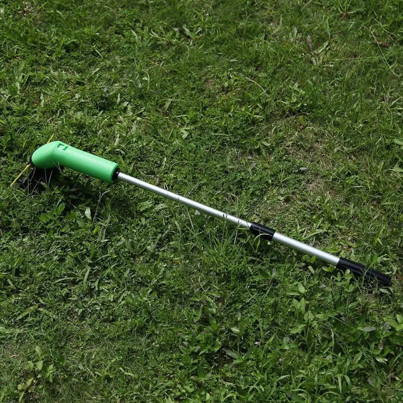 Cordless handheld lawn trimmer with extension pole and protective shield on a garden lawn.