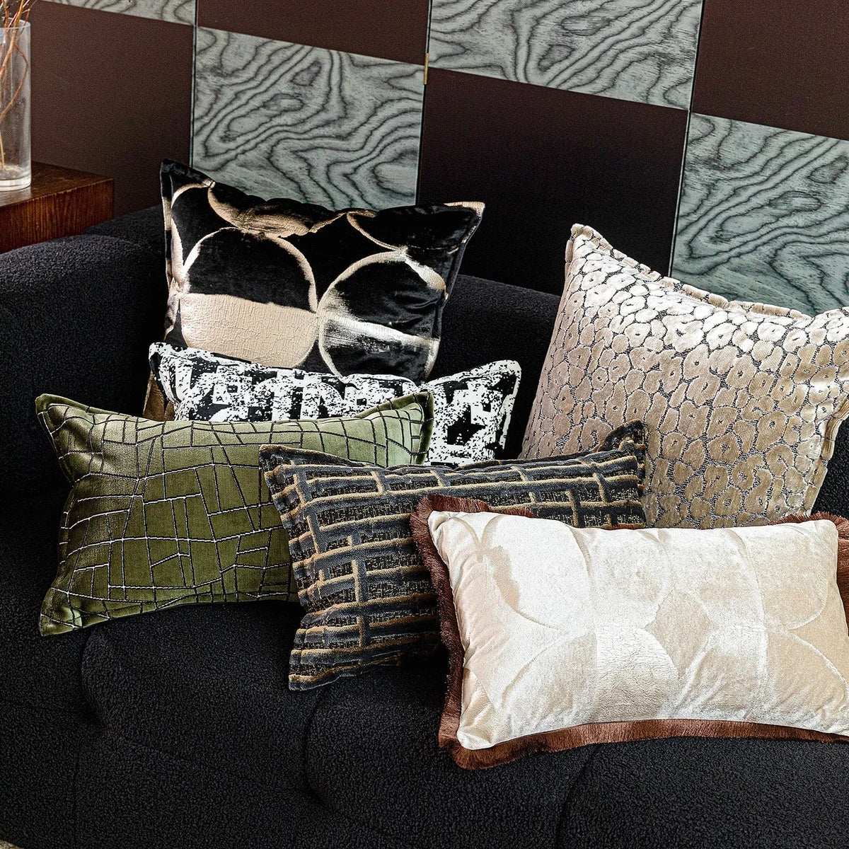 Black and gold abstract pattern square cushion with removable feather velvet cover on a sofa.