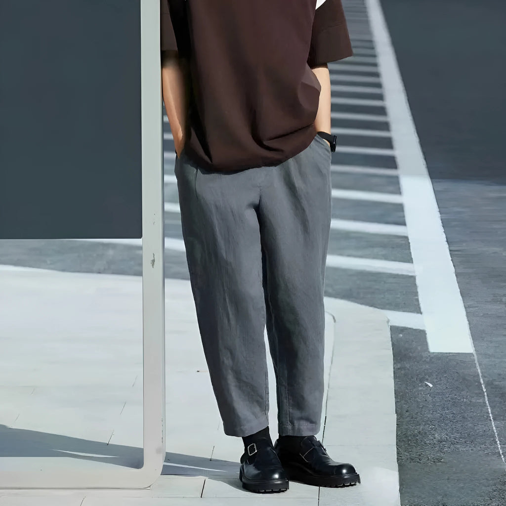 Men's loose straight casual pants with drawstring waist in beige, shown laid flat.