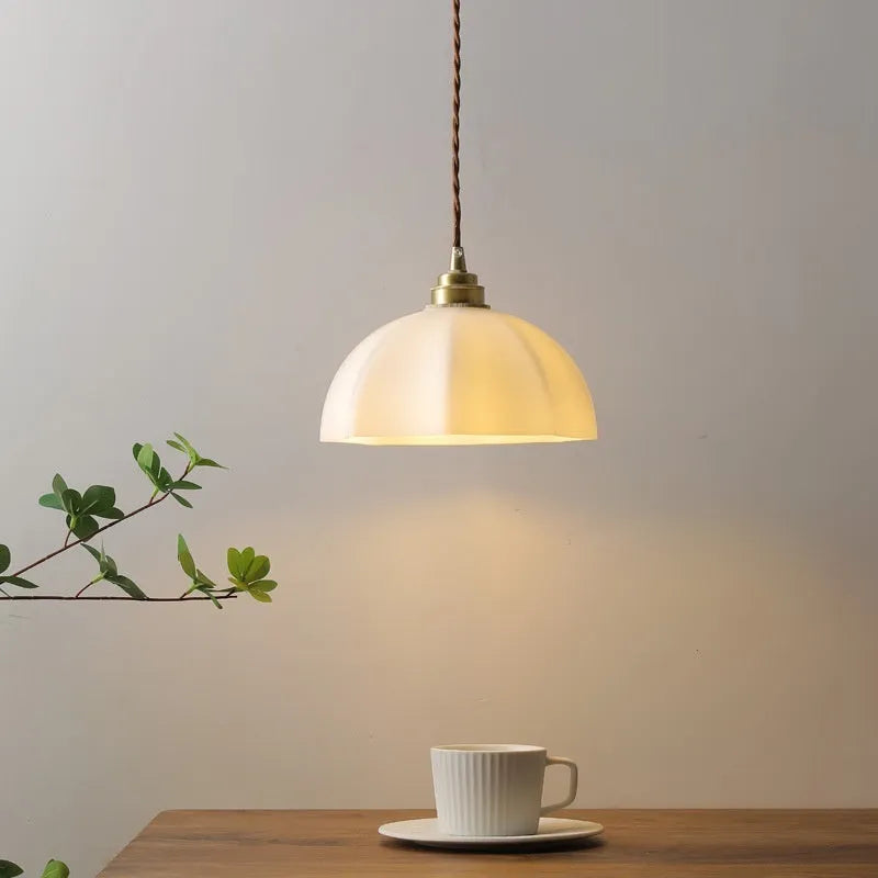 Brass Chinese style pendant light with copper glass shade hanging from ceiling