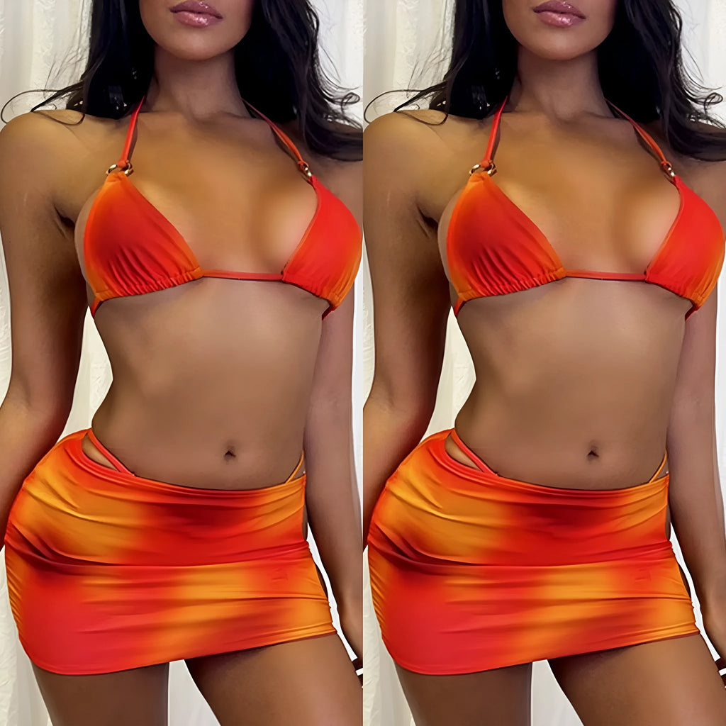 Tie-dye gradient patterned three-piece halter bikini swimsuit set with a skirt on a solid colour background.