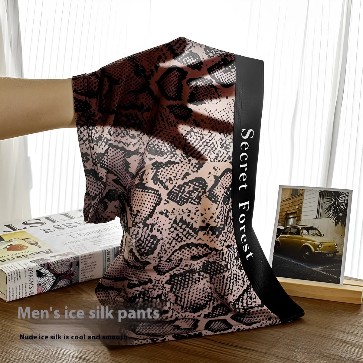 Men's loose fit boxer shorts in thin black polyester fabric laid flat