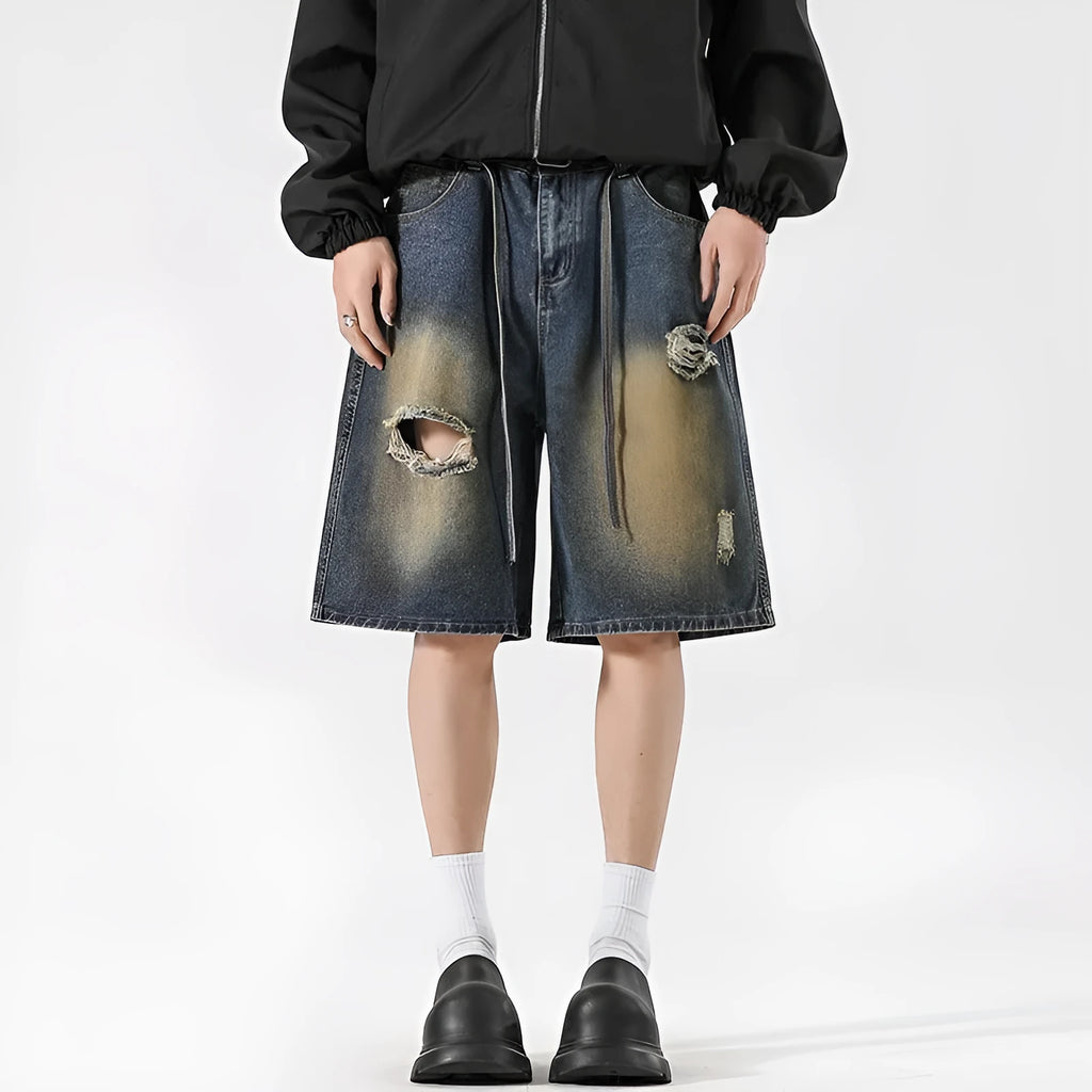 Man's retro blue loose fit jeans with ripped detailing on knees and thighs.