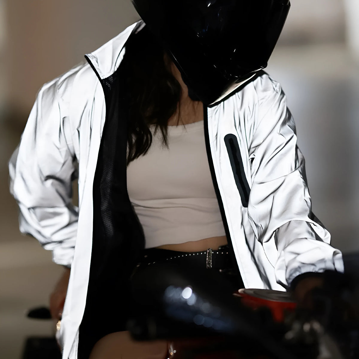 Silver waterproof polyester long sleeved jacket with front zip, shown on a hanger.