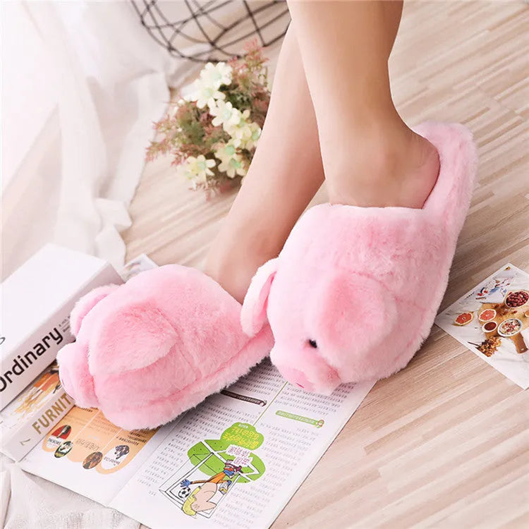 Pink plush pig-themed floor slippers on a white background.