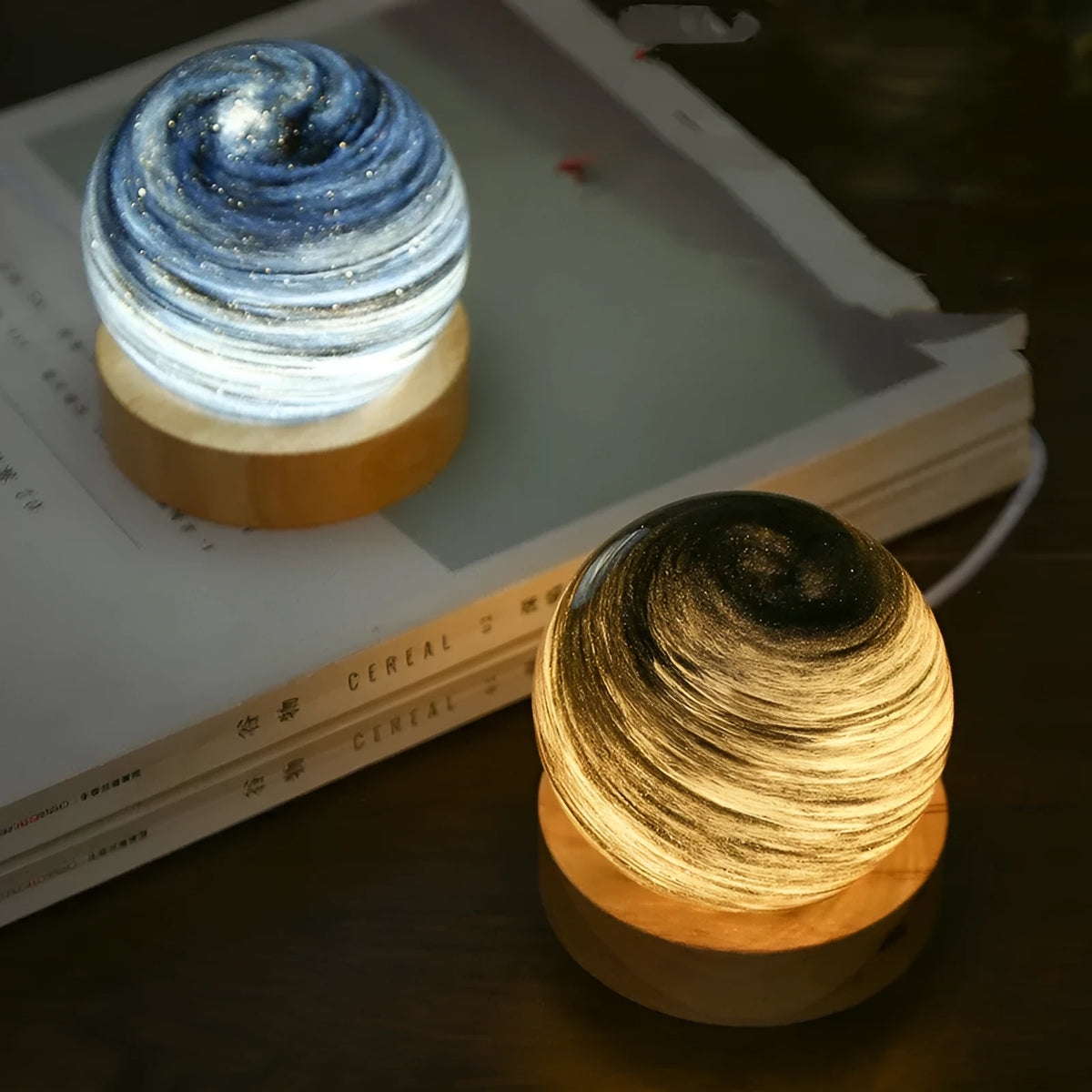 Planet-shaped night light with USB cable on base, showing modern design and colour options.