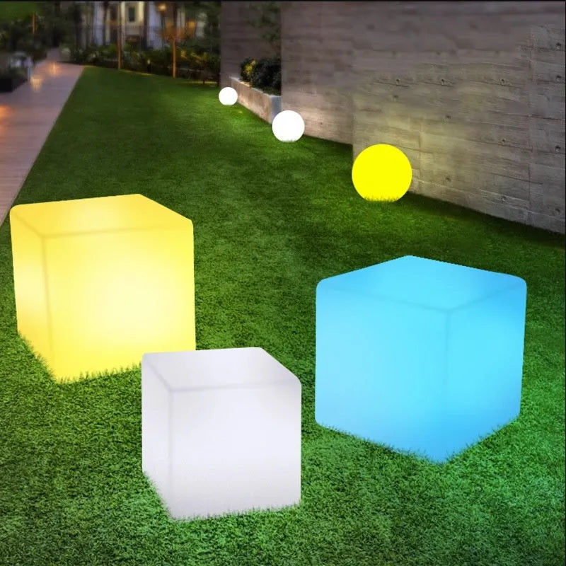 Modern white LED cube stool light outdoors, showing clean square design and soft illumination.