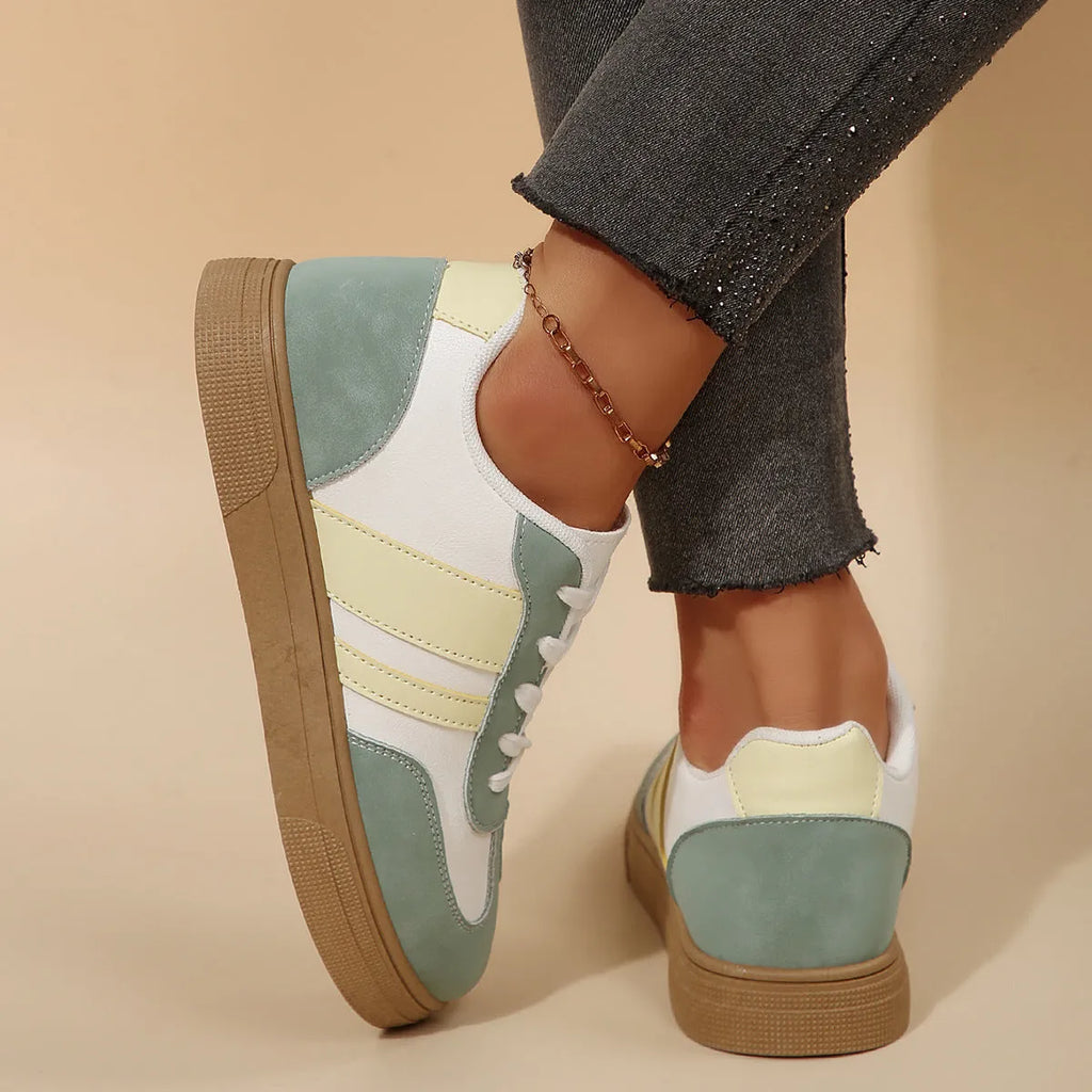 Green women's retro sports pumps with white cross straps and a round toe.