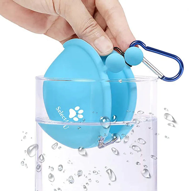 Blue silicone dog treat pouch with hook and loop closure, shown attached to a waistband.