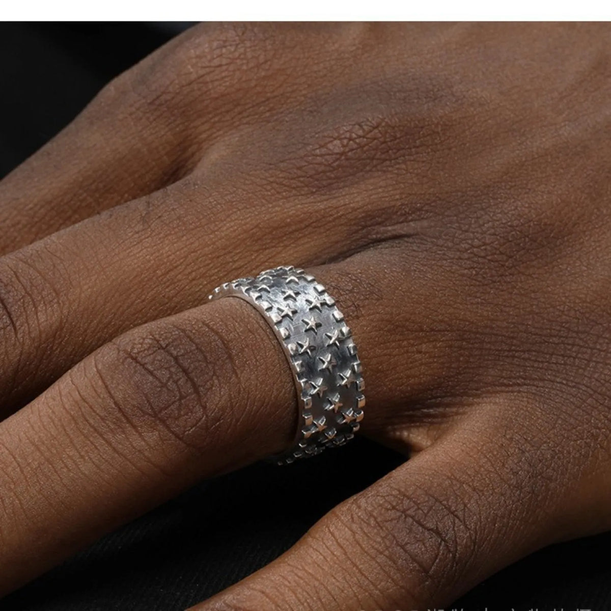 Silver ring with multiple five-pointed star geometric pattern on an adjustable band.