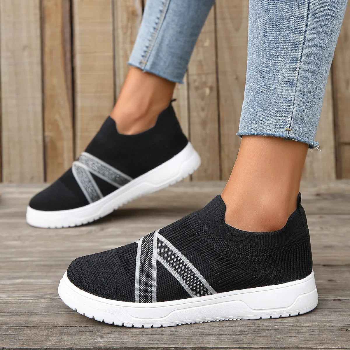 Women's black casual shoes with fabric mesh upper and flat rubber sole on neutral background