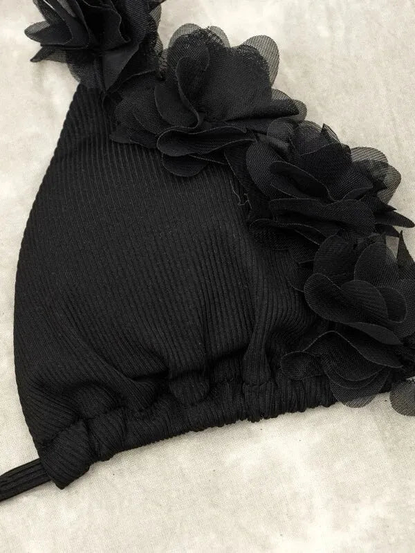 Black women's two-piece swimsuit set with a gathered design top and matching shorts on a neutral background.