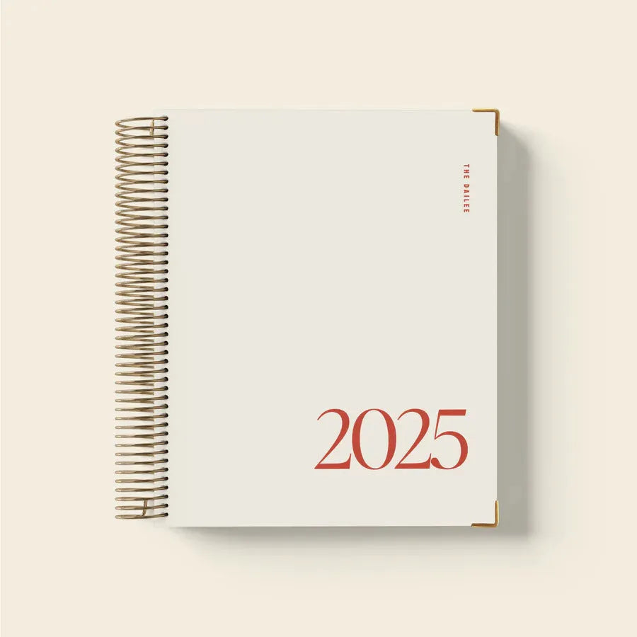 Cherry red daily schedule coil notebook open to show wire-o binding and planner layout.