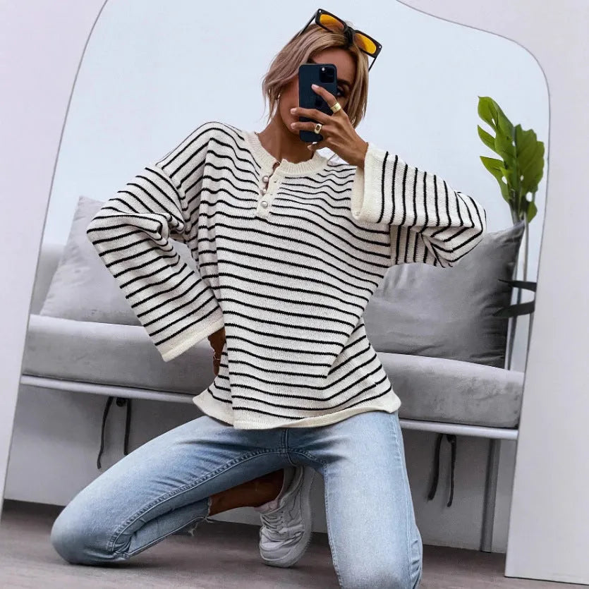 Black striped women's knitted top with drop shoulder sleeves on hanger