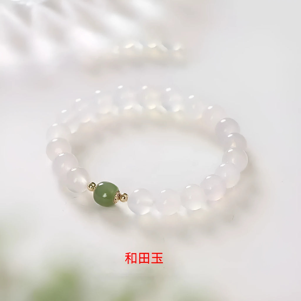 Handmade white agate and Hetian jade bracelet with red cinnabar inlay and a text charm.