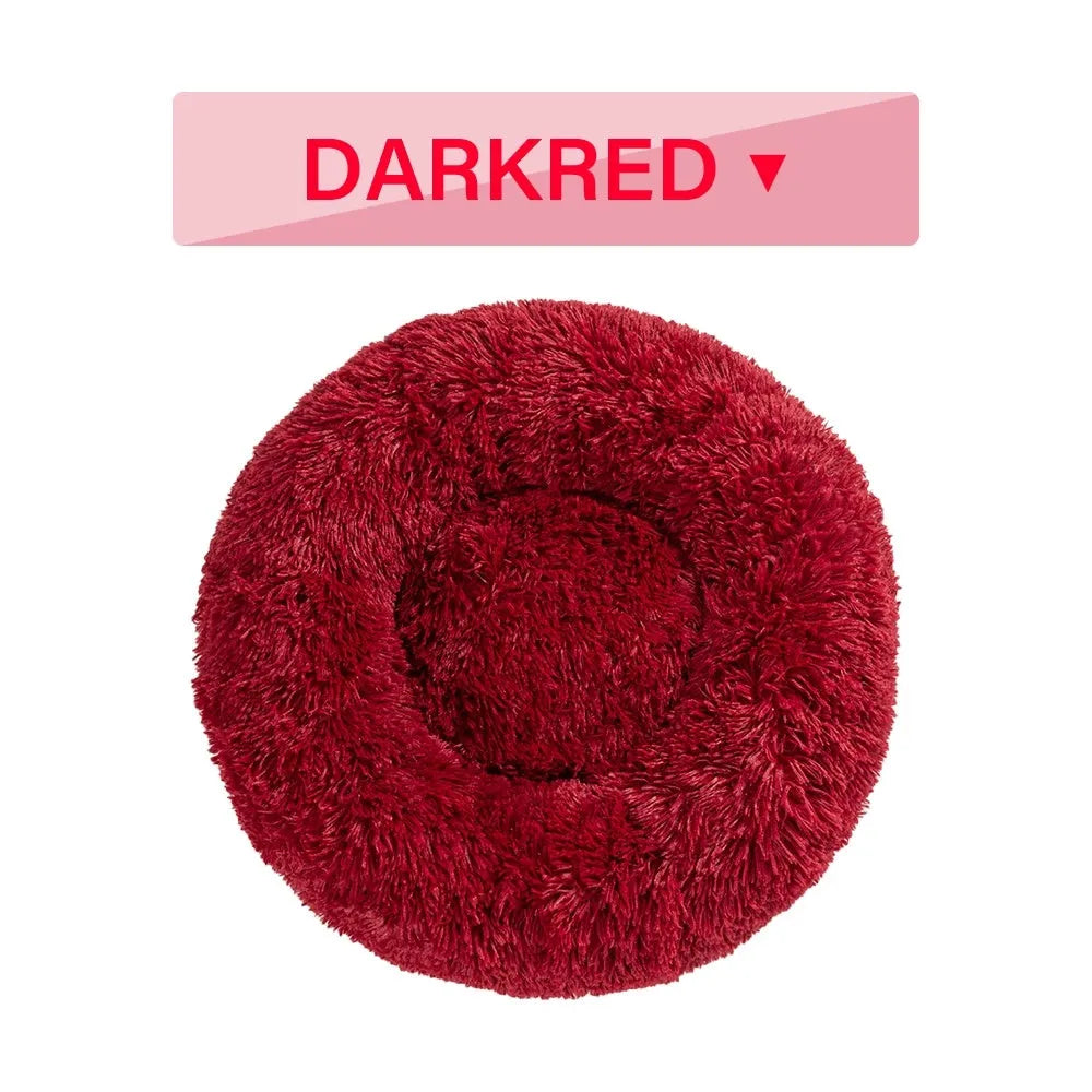 Fluffy donut-shaped dog bed in long plush material, shown in one of multiple available colours